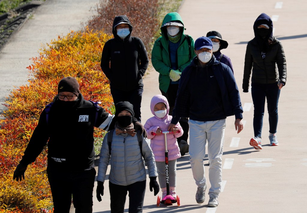 Família caminha em Daegu, na Coreia do Sul, usando máscaras