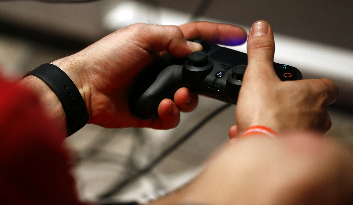 Jogador com o controle do PlayStation 4, da Sony
