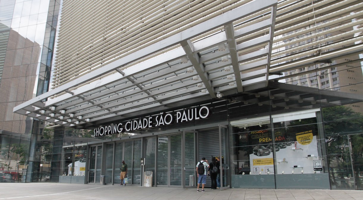 Pouquíssimos pedestres passam pela fachada do Shopping Cidade São Paulo, na Avenida Paulista, região central da capital, fechado para o público, a partir desta quinta-feira (19)
