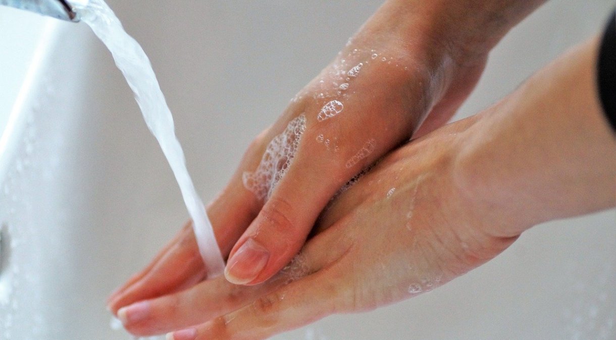 Mulher lava as mãos com sabão