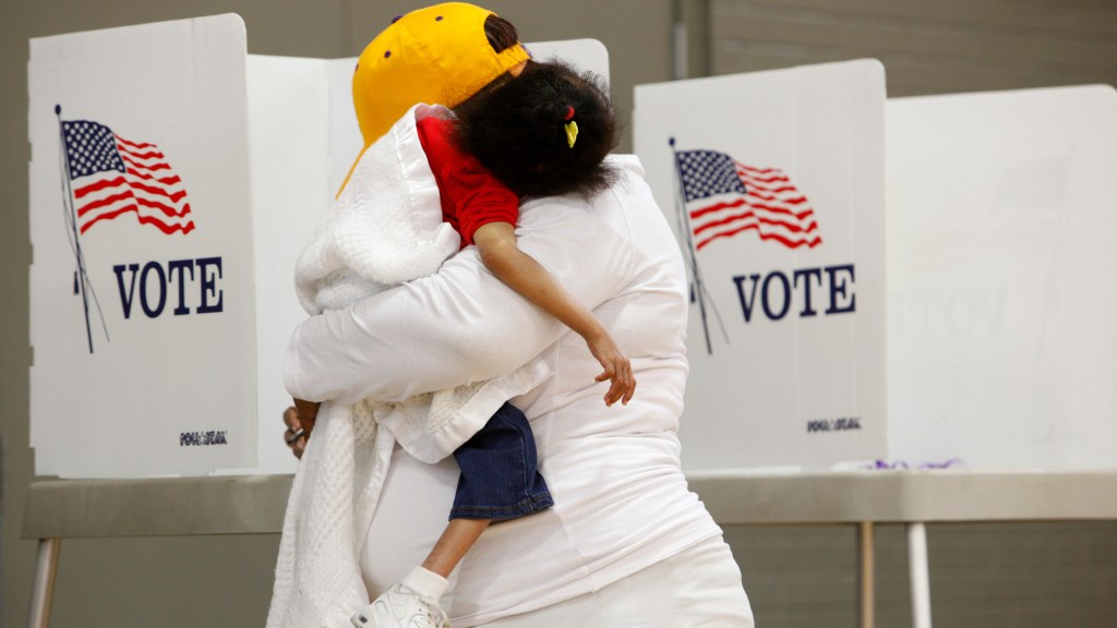 Com a filha no colo, mulher vota na eleição presidencial dos EUA, em 2016