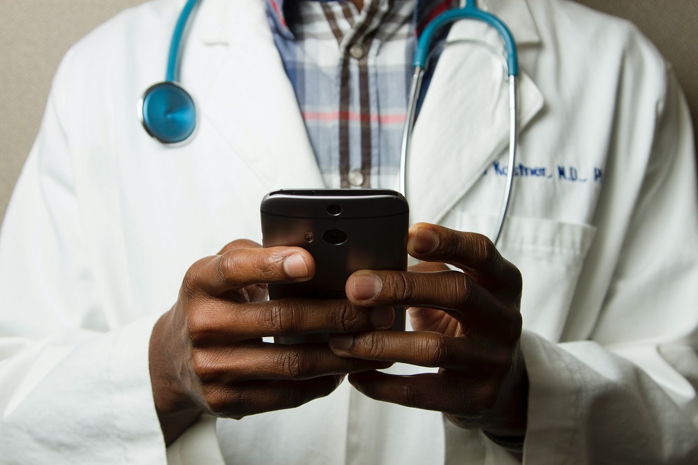 Médico segurando celular: mercado de startups de saúde está aquecido