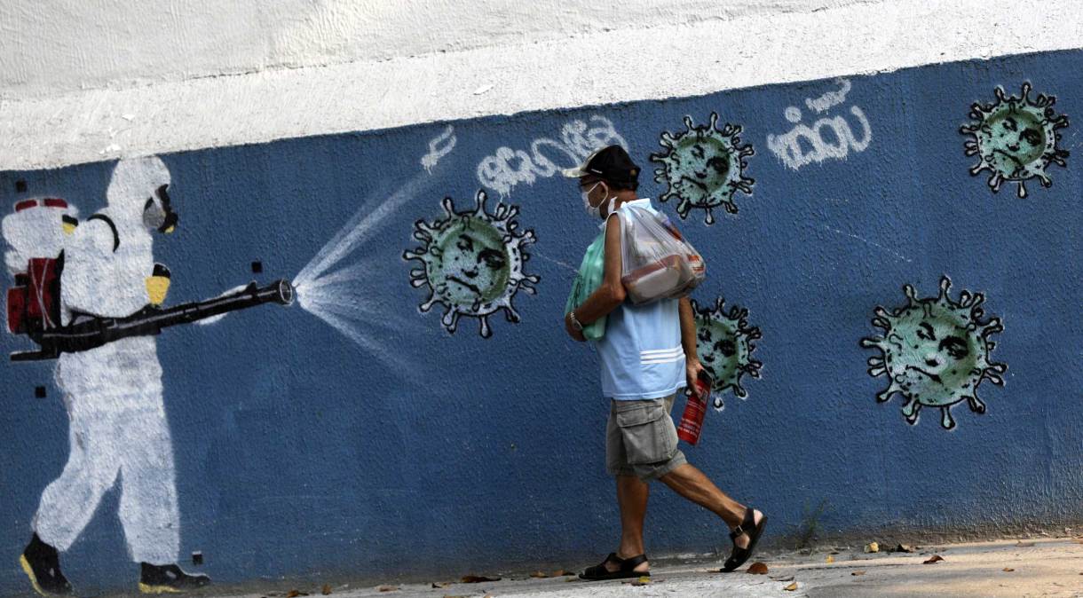 Homem passa por grafite no Rio de Janeiro durante pandemia da Covid-19