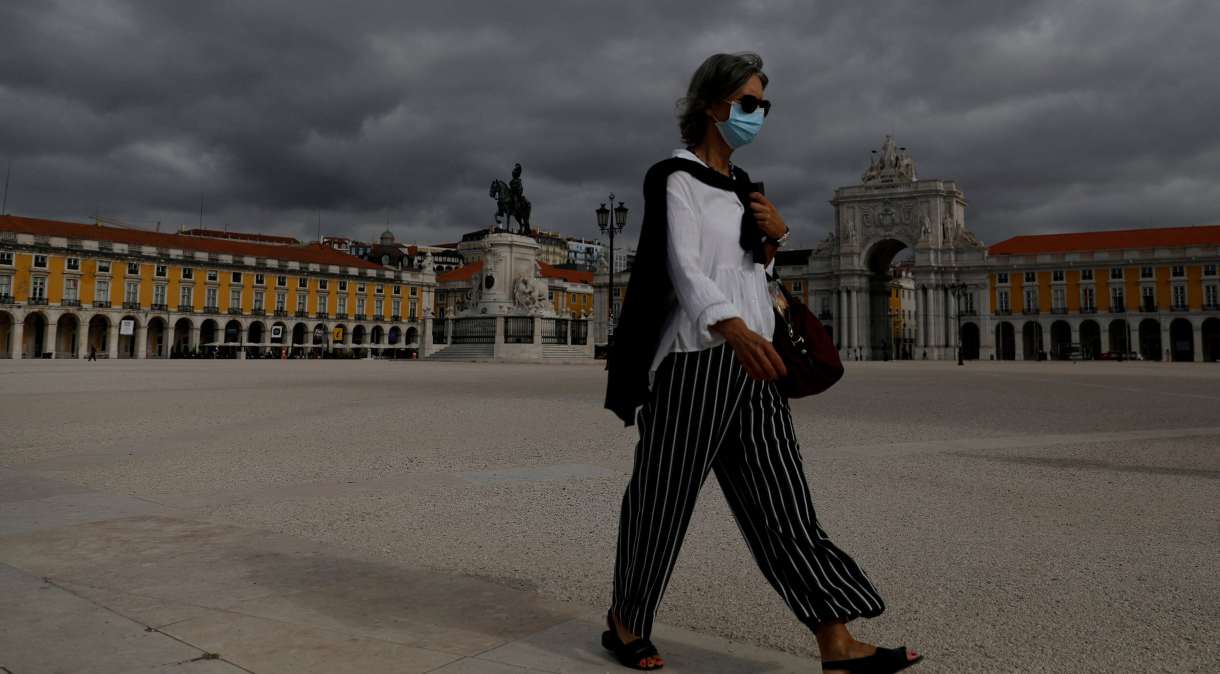 Mulher de máscara caminha na Praça do Comércio, em Lisboa
