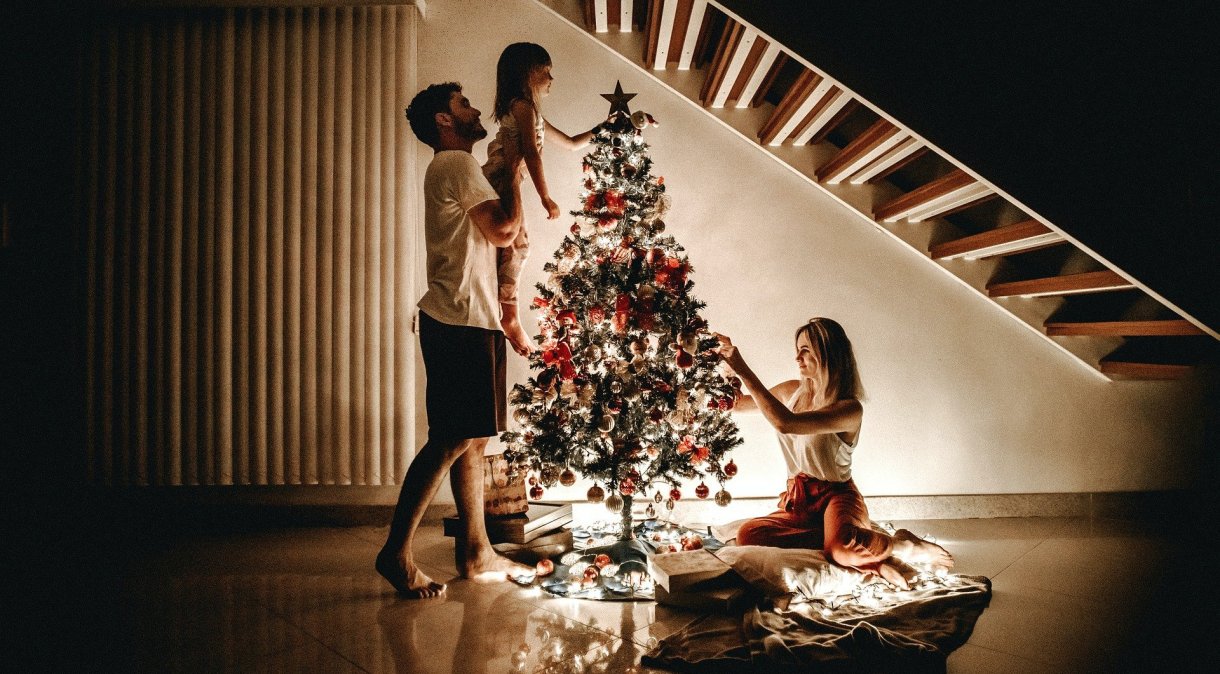 Família reunida em torno de árvore de Natal