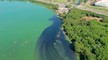 Uma mancha verde com cianobactérias, que se reproduzem na água contaminada pelo esgoto, está em uma lagoa a apenas quatro quilômetros da orla