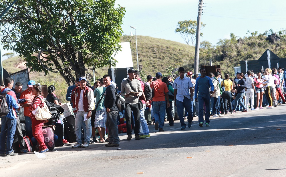 Imigrantes venezuelanos cruzam a pé a fronteira entre Venezuela e Brasil