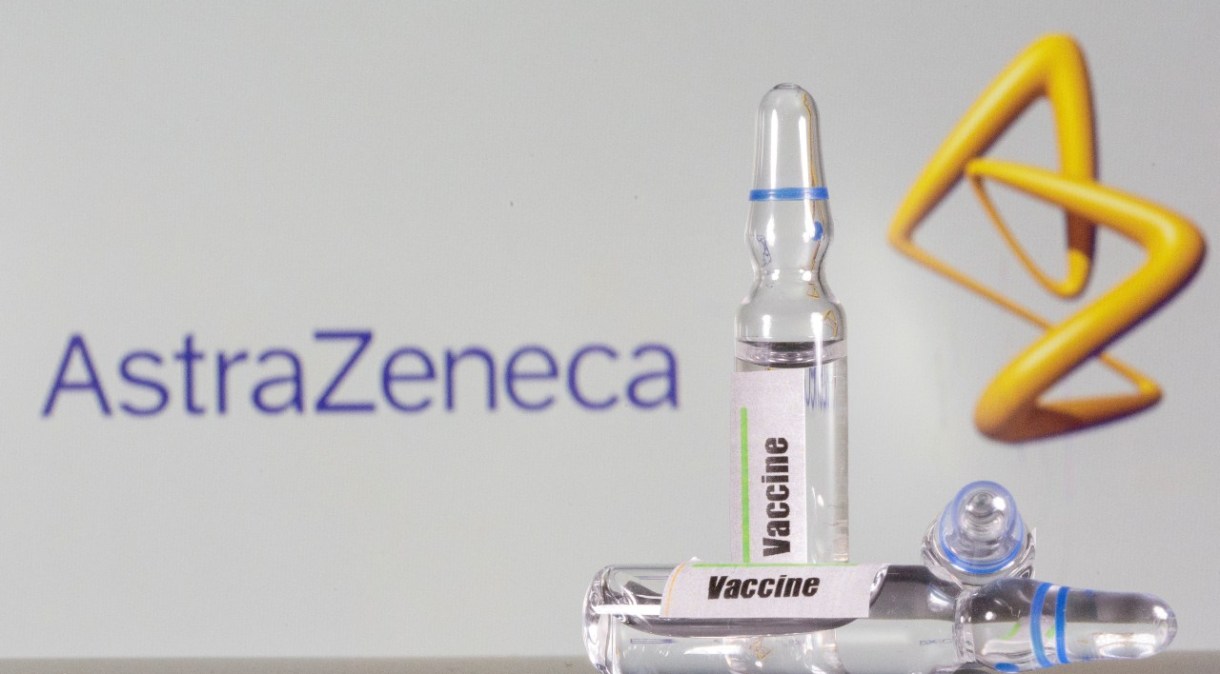 Tubo de ensaio rotulado como de vacina em frente ao logo da AstraZeneca em foto de ilustração (09/09/2020)