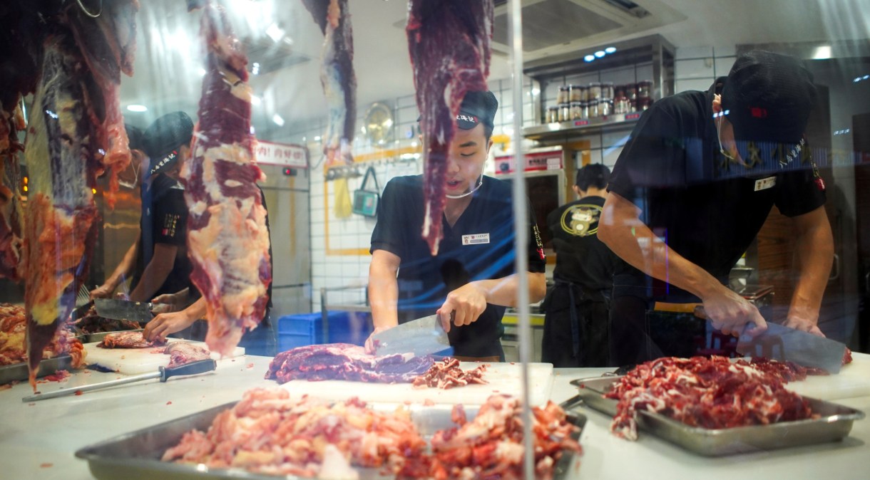 Funcionários cortam carnes na China: lote de frango de origem brasileira foi encontrada na China contaminada pela Covid-19