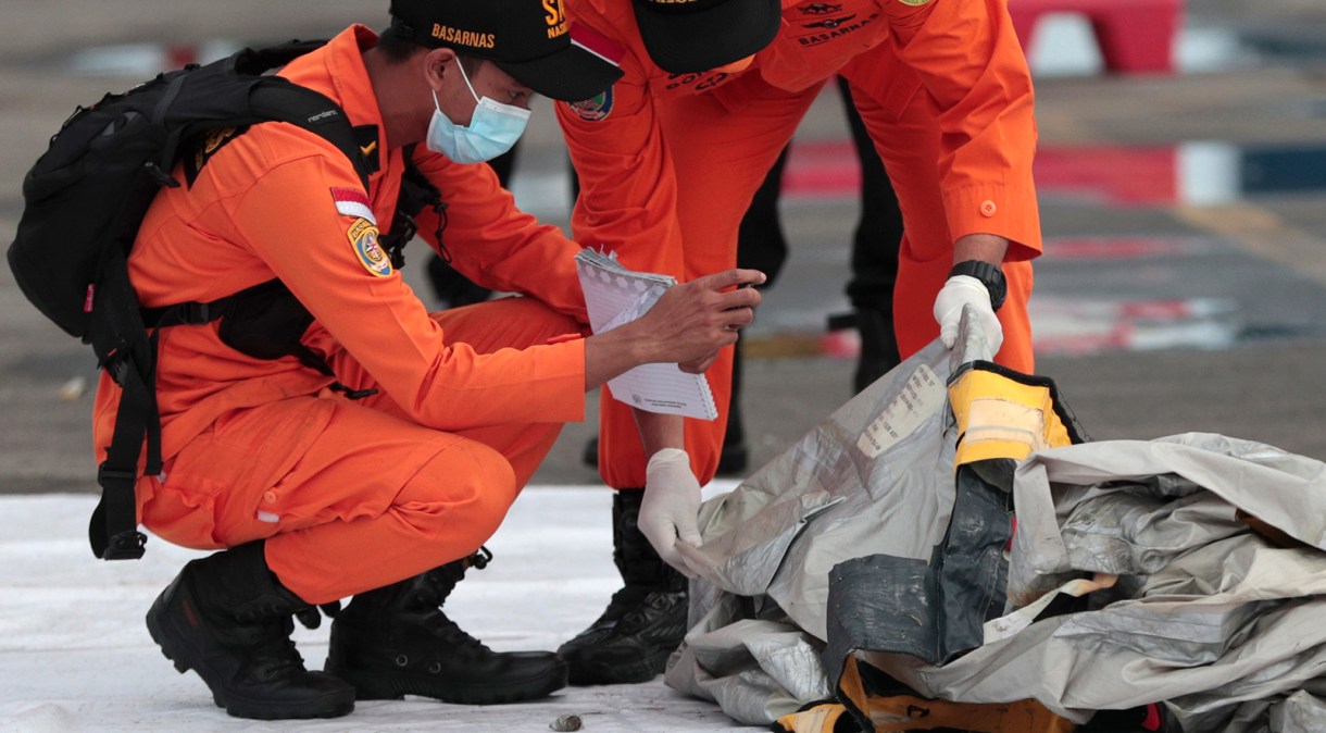 Equipe de resgate analisa destroços encontrados no local da queda da aeronave, no Mar de Java