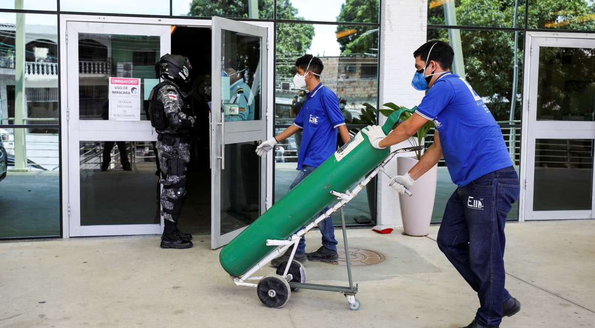 Trabalhadores chegam a hospital em Manaus, no Amazonas, com cilindro de oxigênio em meio a colapso do sistema de saúde causado pela pandemia da Covid-19