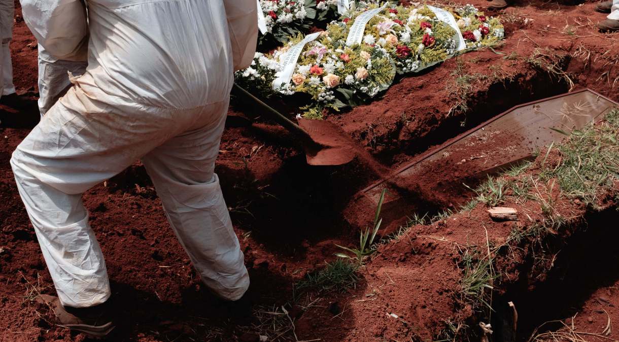 Agente funerário sepulta caixão no cemitério da Vila Formosa, em São Paulo, durante pandemia da Covid-19