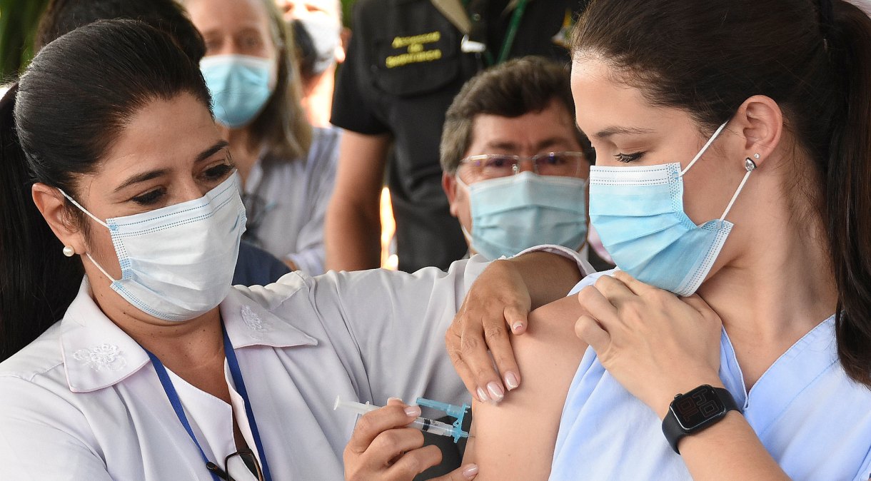 A enfermeira Lídia Rodrigues Dantas (D) foi a primeira pessoa vacinada contra Covid-19 no Distrito Federal