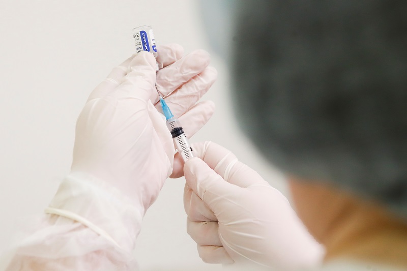 Profissional de saúde enche seringa com vacina