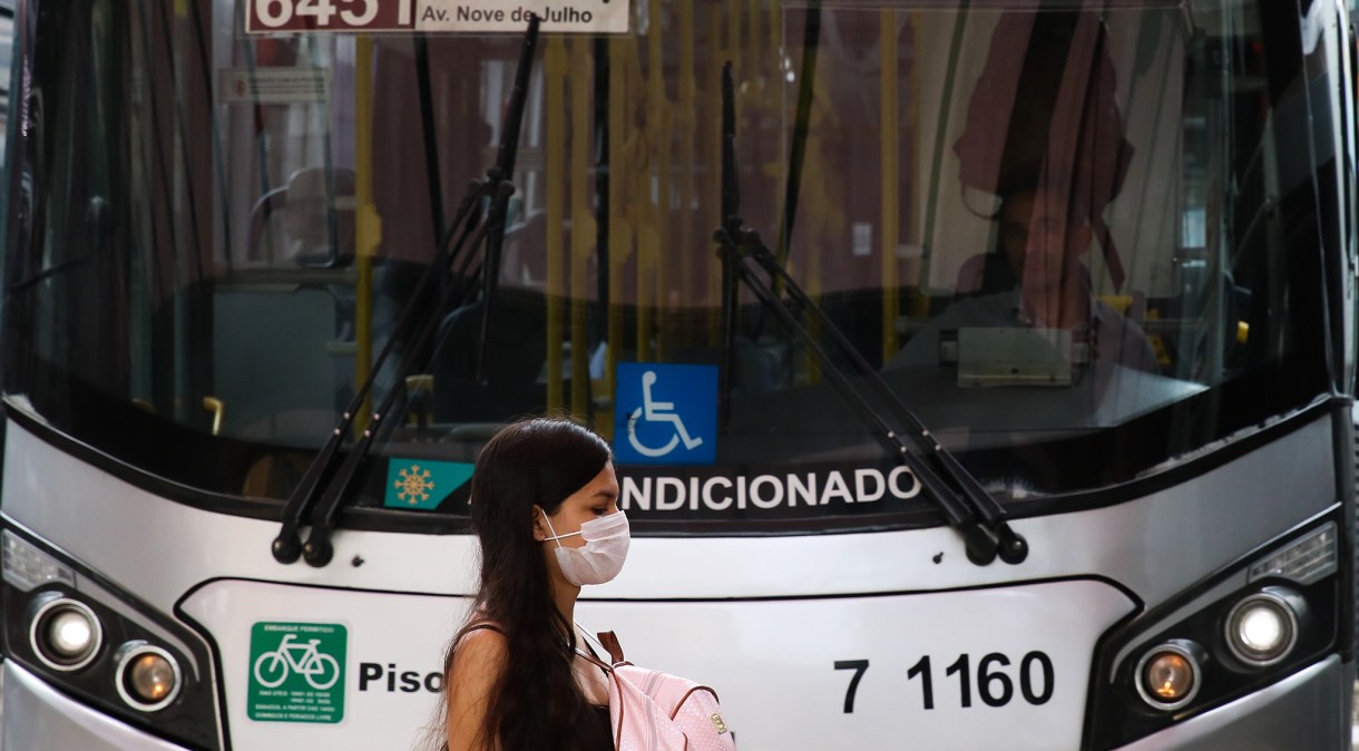 Transeunte usa máscara protetora em terminal de ônibus em São Paulo