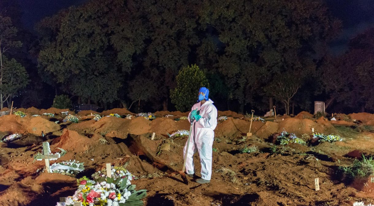 Coveiro com traje de proteção no cemitério da Vila Formosa, em São Paulo, durante pandemia da Covid-19