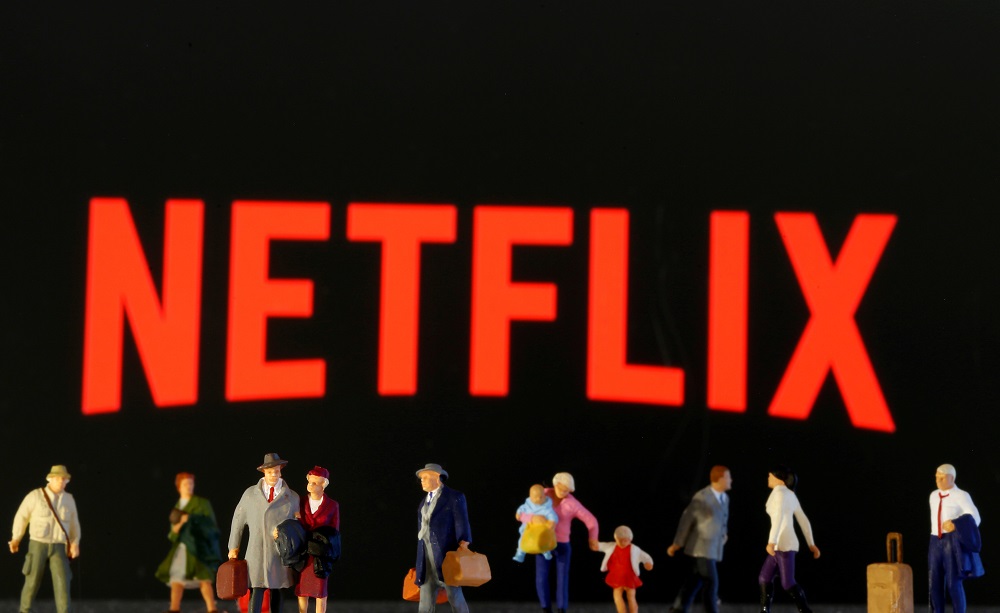 Figuras de brinquedo aparecem em frente ao logotipo da Netflix: base de assinantes da gigante do streaming teve alta com quarentena (19.mar.2020)