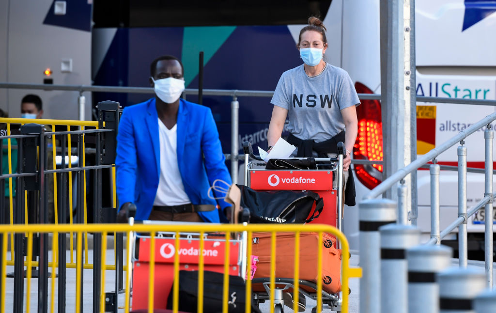 Passageiros usando máscaras chegam ao Aeroporto Internacional de Sydney