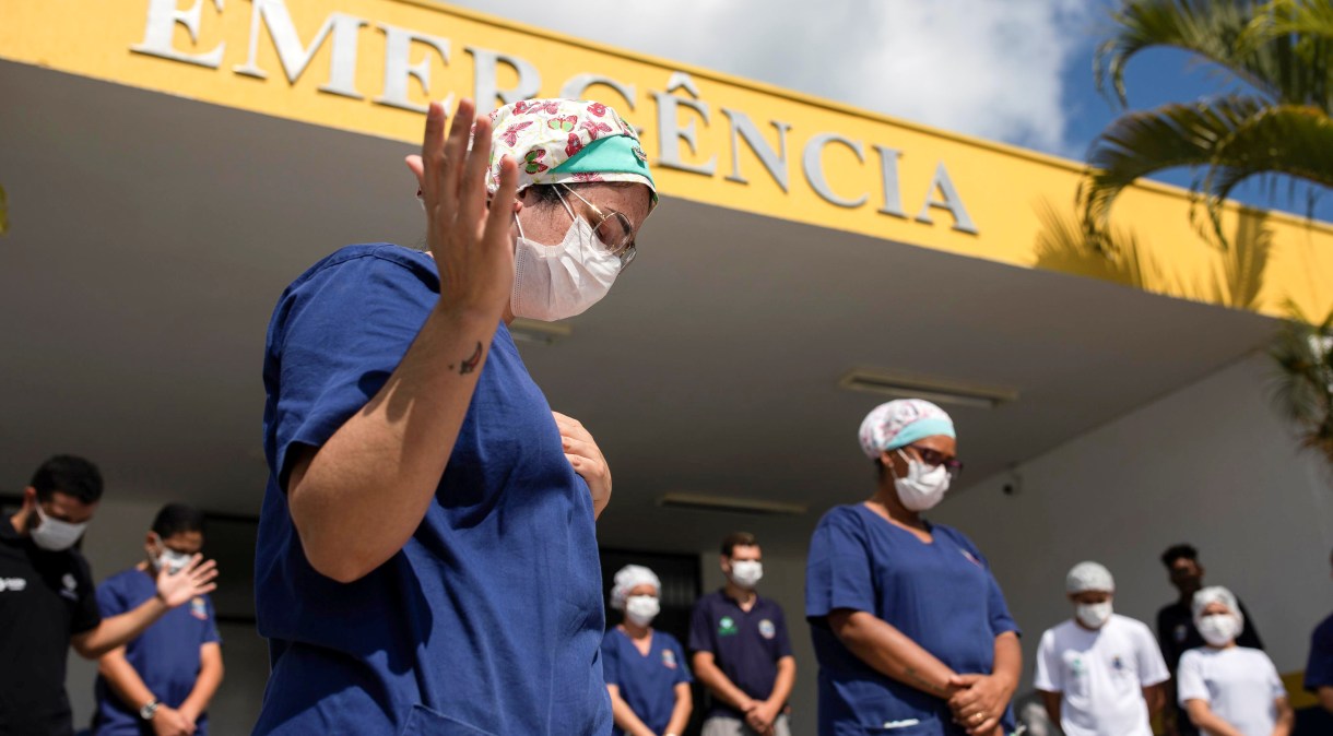 Profissionais de saúde rezam em frente a hospital em lhabela, litoral de São Paulo