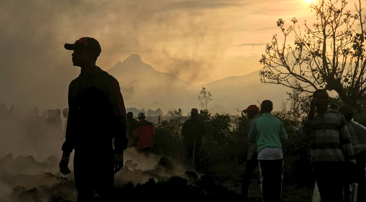 Moradores caminham perto de casas destruídas por lava de vulcão no arredores de Goma, na República Democrática do Congo