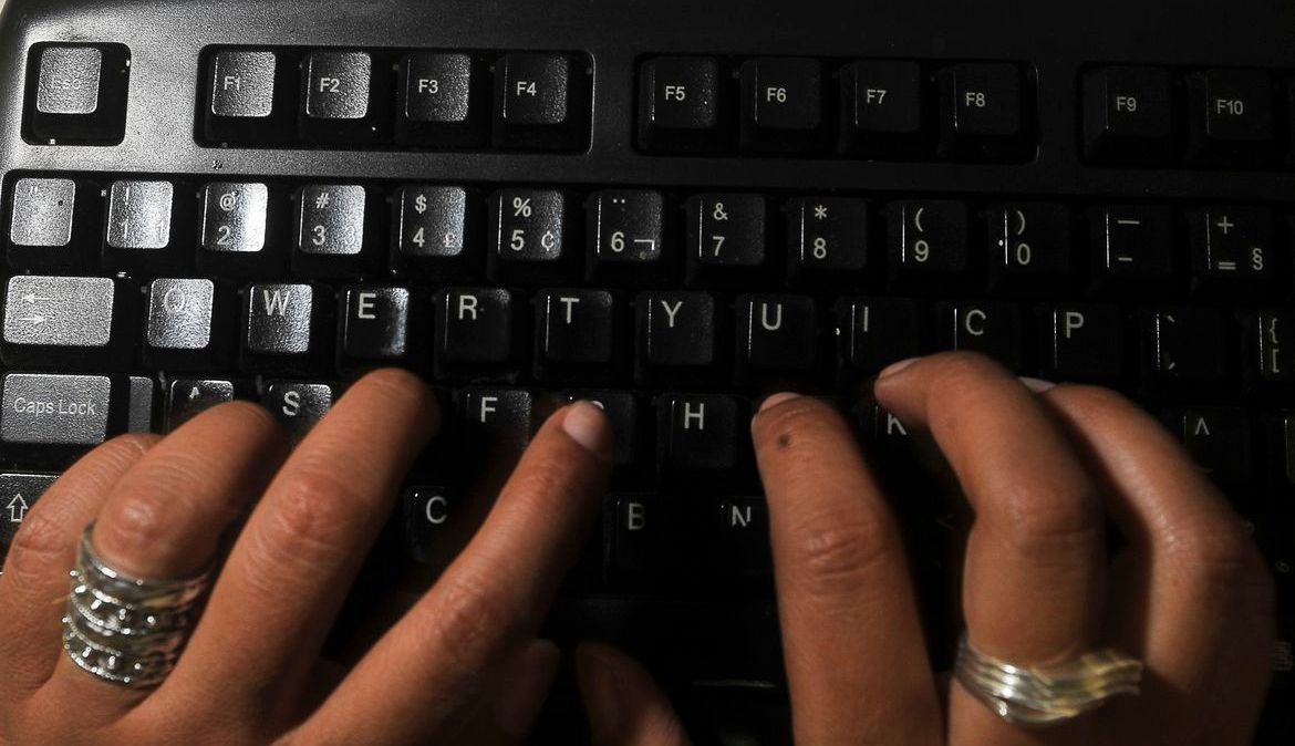 Mulher escrevendo em teclado de computador