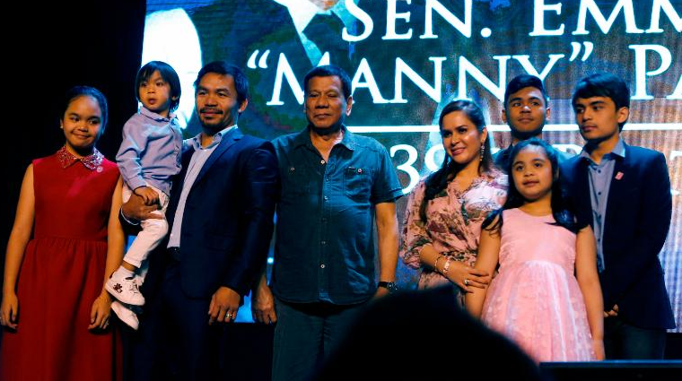 O boxeador Manny Pacquiao (segundo à esquerda) é visto com o presidente Rodrigo Duterte e sua família quando ele comemora seu 39º aniversário em dezembro de 2017