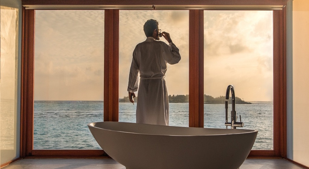 Homem contempla paisagem em sala com banheira: Luxos de uma vida milionária podem ser efêmeros