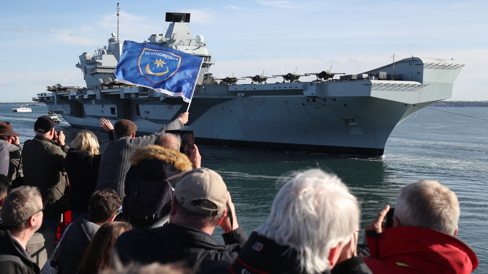 O porta-aviões britânico HMS Queen Elizabeth é saudado ao chegar à Base Naval