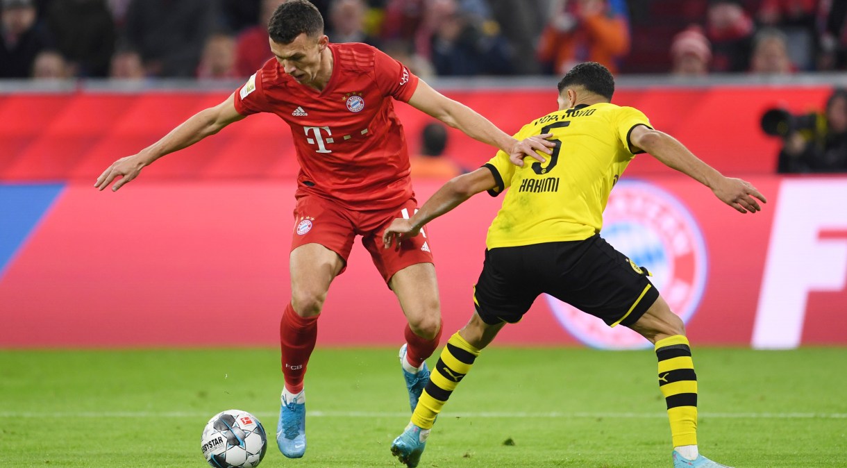 Jogadores do Bayern de Munique e Borussia Dortmund disputam lance em jogo no fim de 2019