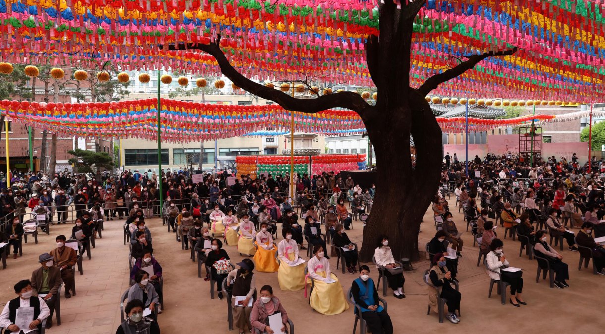 Budistas se reúnem em templo em Seul, na Coreia do Sul, usando máscaras e em cadeiras distantes uma das outras 
