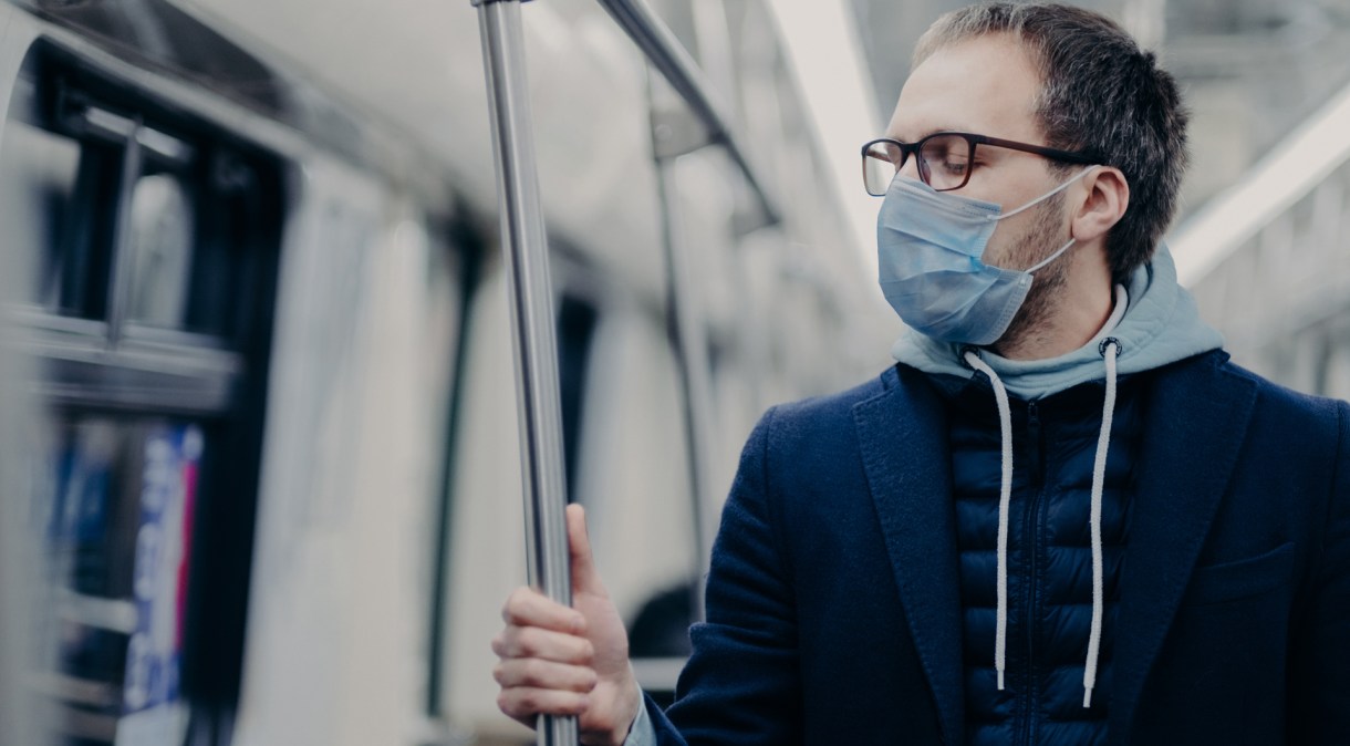Homem usa máscara e óculos de grau no metrô durante pandemia da Covid-19.