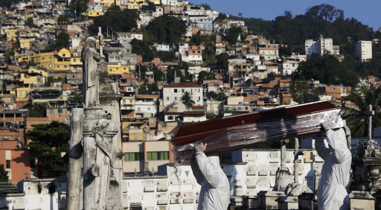 Coveiros com roupas de proteção carregam caixão de vítima do novo coronavírus (Covid-19) no Rio de Janeiro