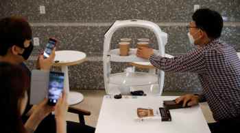 O sistema, que usa um braço robótico para fazer café e um robô para servir, pode fazer 60 tipos de café e serve as bebidas para os clientes em seus assentos