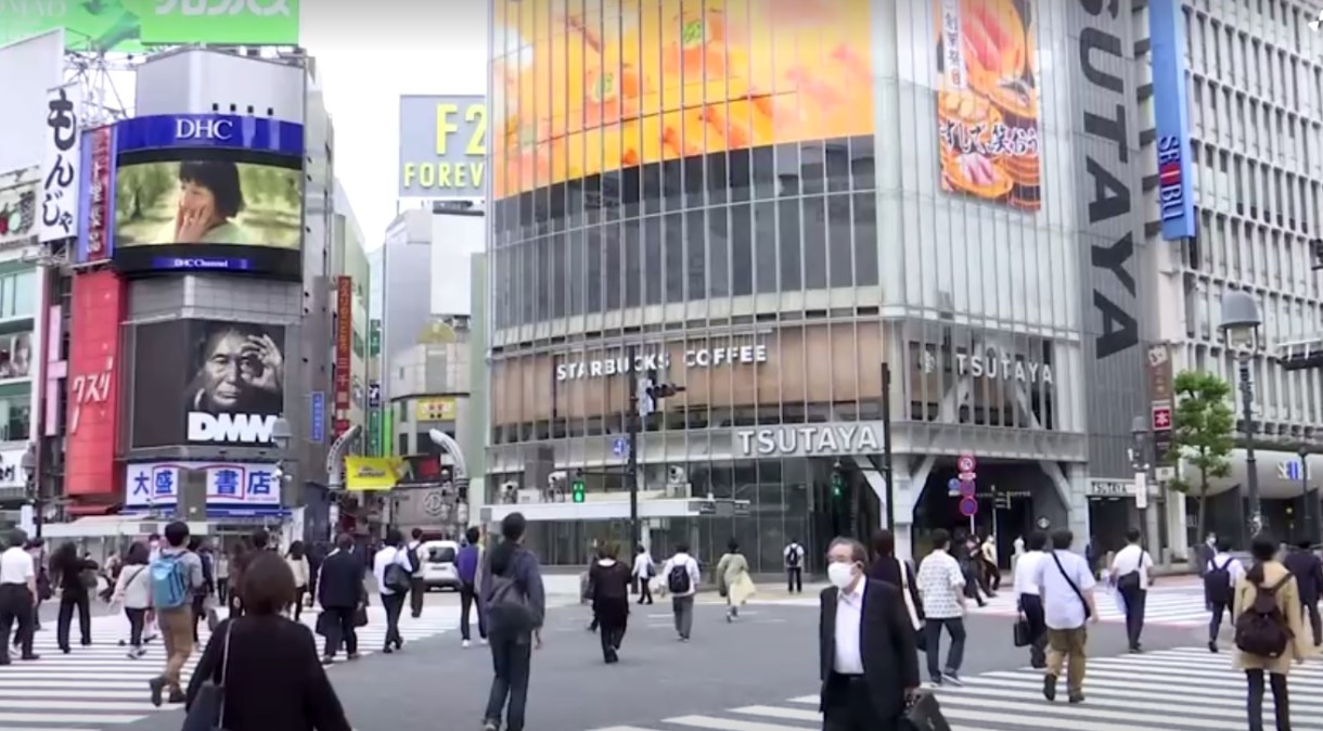 Japoneses caminham no cruzamento de Shibuya, em Tóquio