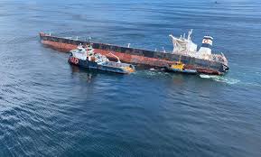 O navio Stellar Banner, encalhado na costa do Maranhão, e uma embarcação especializada para retirar óleo