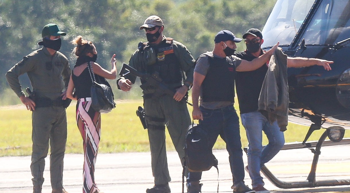 Cercado por policiais, Fabrício Queiroz (2º à direita), desembarca de helicóptero no Aeroporto de Jacarepaguá, no Rio