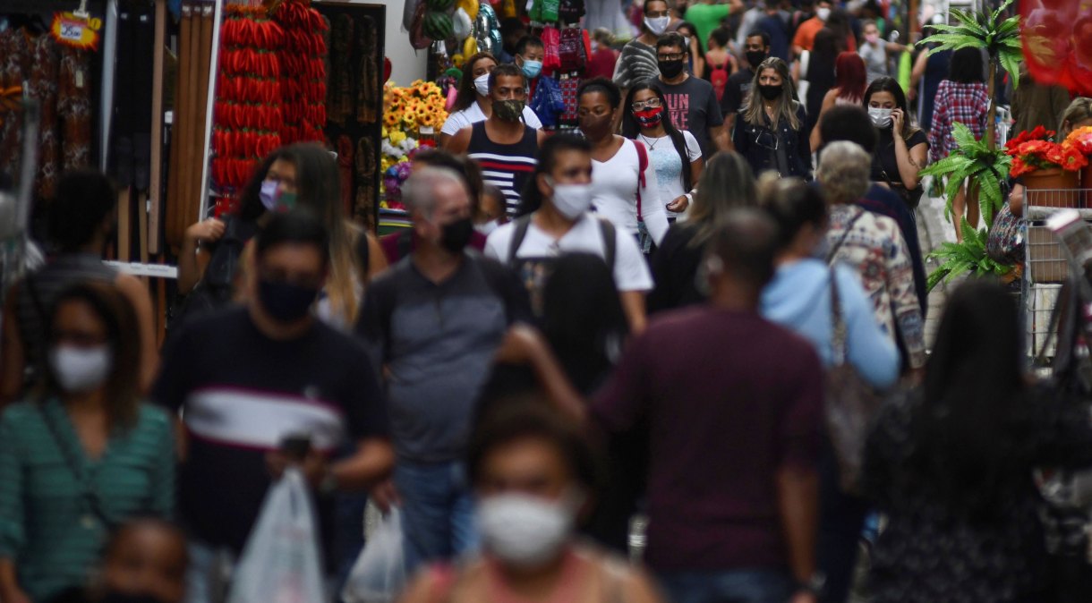 Pessoas circulam de máscara por rua de comércio popular no centro do Rio de Janeiro durante pandemia da Covid-19