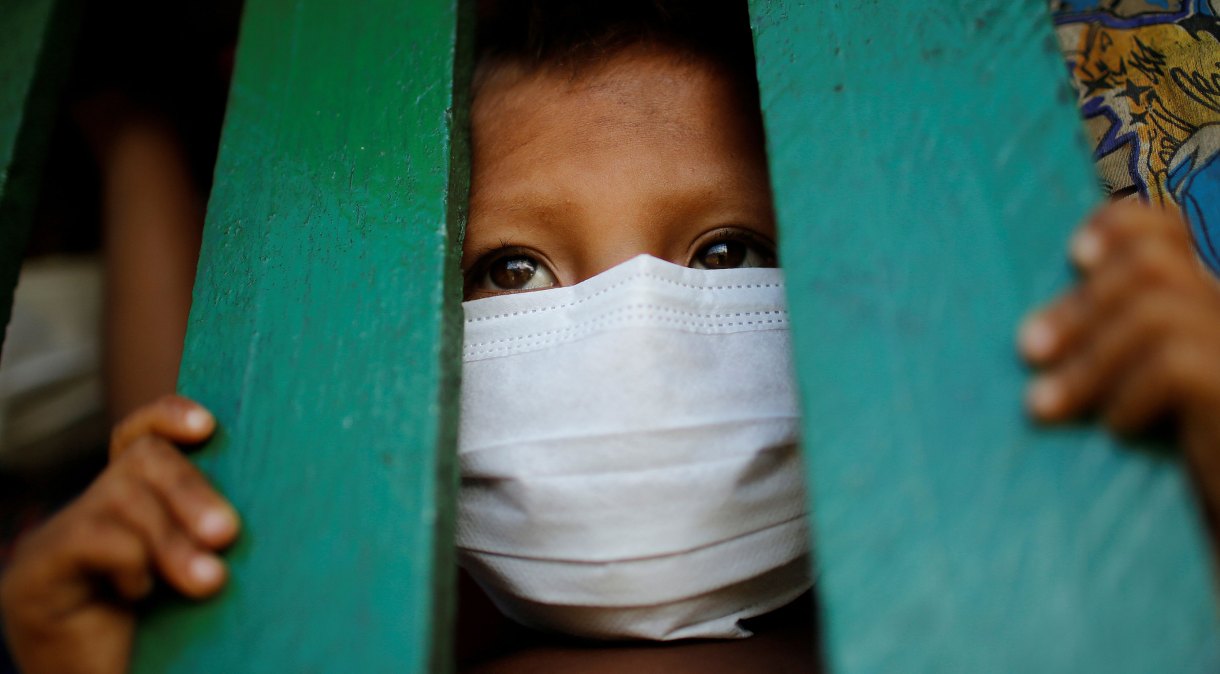 Criança yanomami usa máscara de proteção facial em Roraima