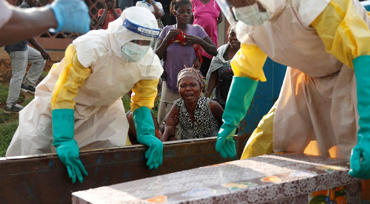 Mãe de criança suspeita de ter morrido de ebola chora ao lado do caixão, em Beni, na República Democrática do Congo