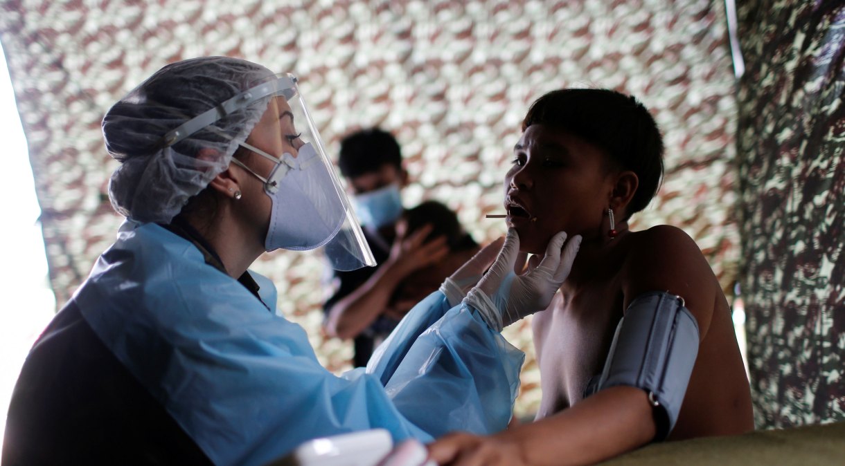 Médica das Forças Armadas examina mulher Yanomami em Alto Alegre, em Roraima