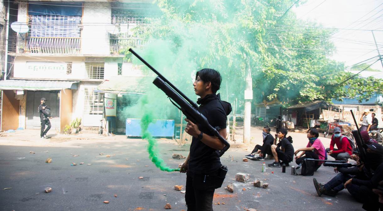 Manifestante segura arma caseira feita com canos durante protesto contra golpe militar em Mianmar
