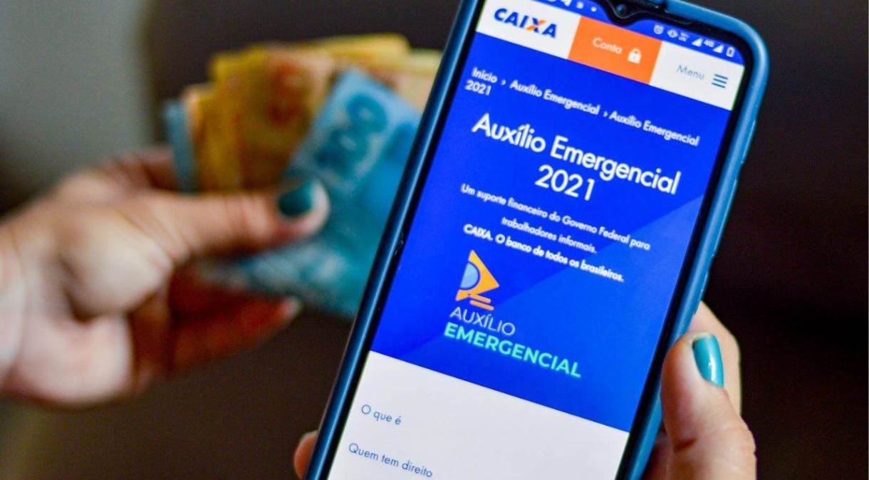 Celular exibe tela inicial do site da Caixa com informações sobre o auxílio emergencial pago em 2021 pelo governo federal