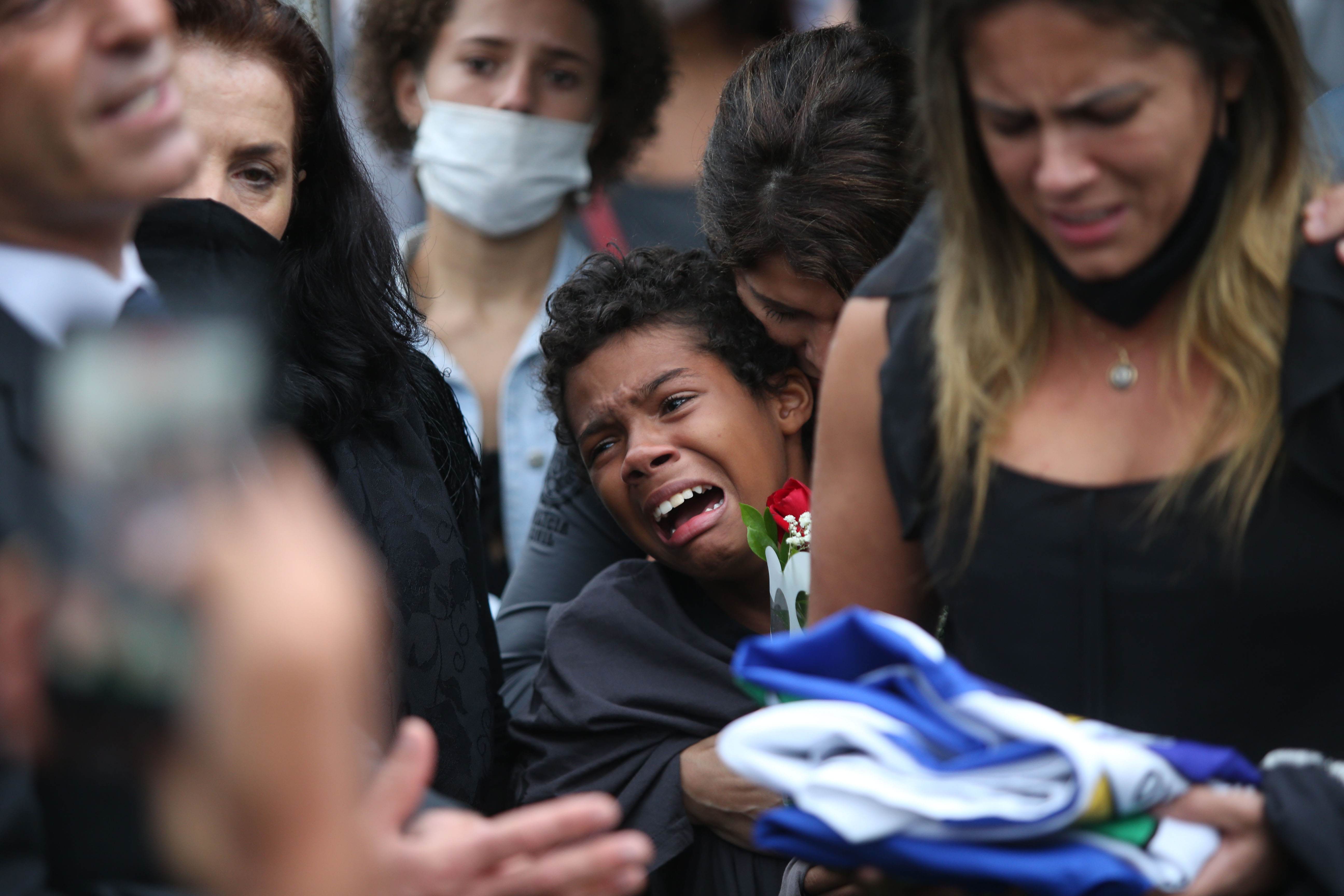 O enteado do policial morto na operação da comunidade do Jacarezinho chora 