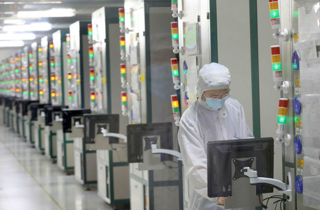 Trabalhador chinês na linha de produção de chips semicondutores com pastilhas de silício na província de Jiangsu, na China