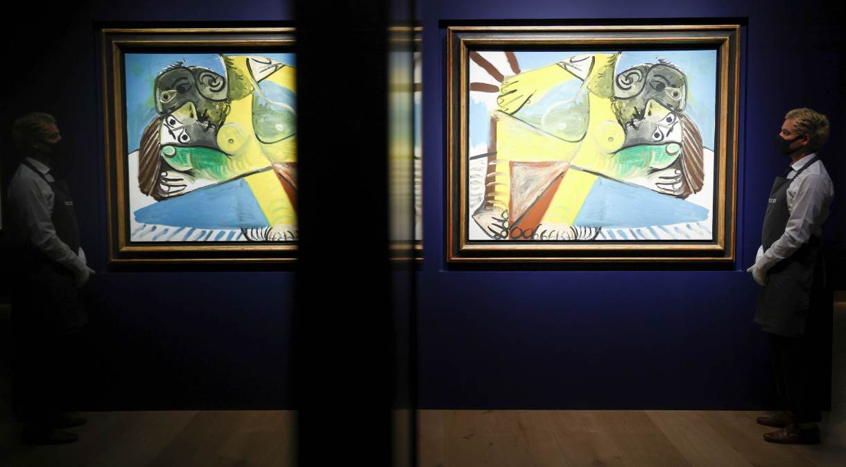 Assistente de galeria posa ao lado de obra do pintor Picasso