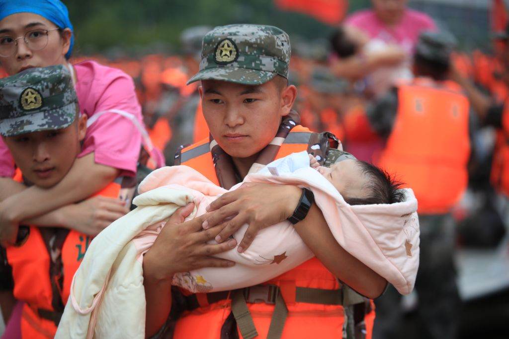 Bombeiro resgata bebê em enchentes históricas em Henan, China 