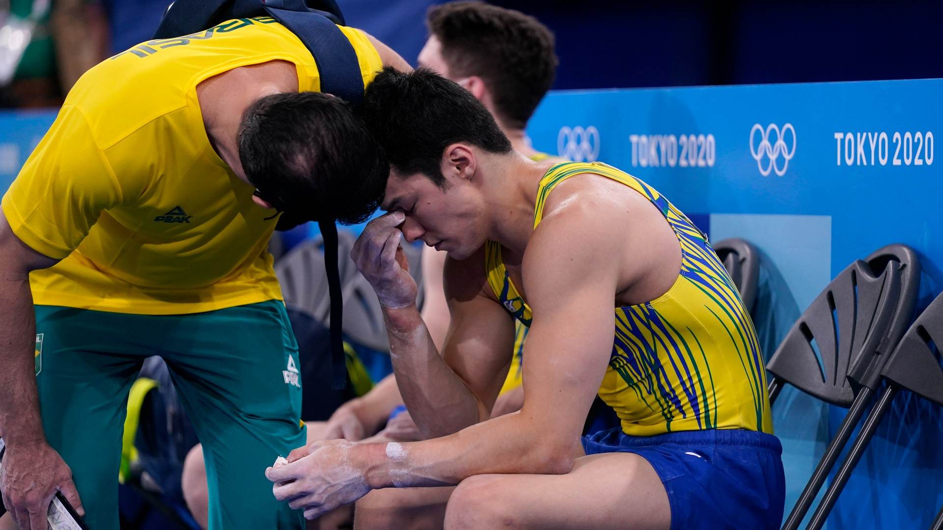 Arthur Nori é consolado por seu técnico após prova de classificação da ginástica