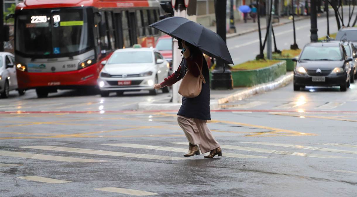 Pedestres se protegem da chuva na região central da cidade de São Paulo.