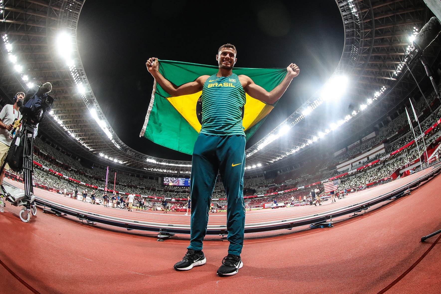 Thiago Braz com a bandeira brasileira após ficar com o bronze no salto com vara