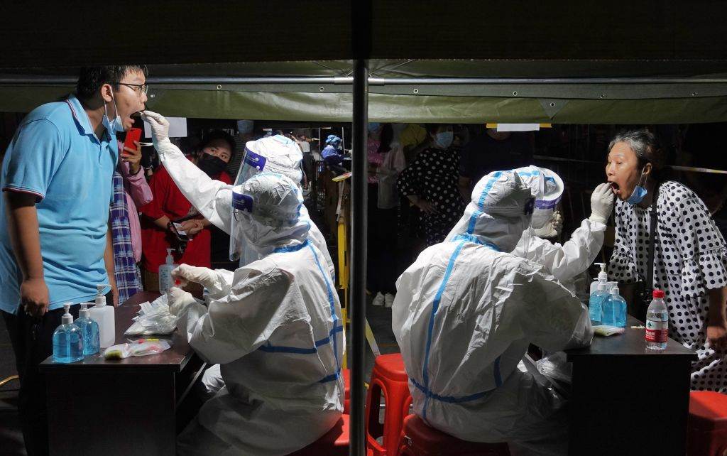 Testes em massa são realizados em todo o país; na foto, cidadãos de Yantai, na província de Shandong, passam pelo procedimento